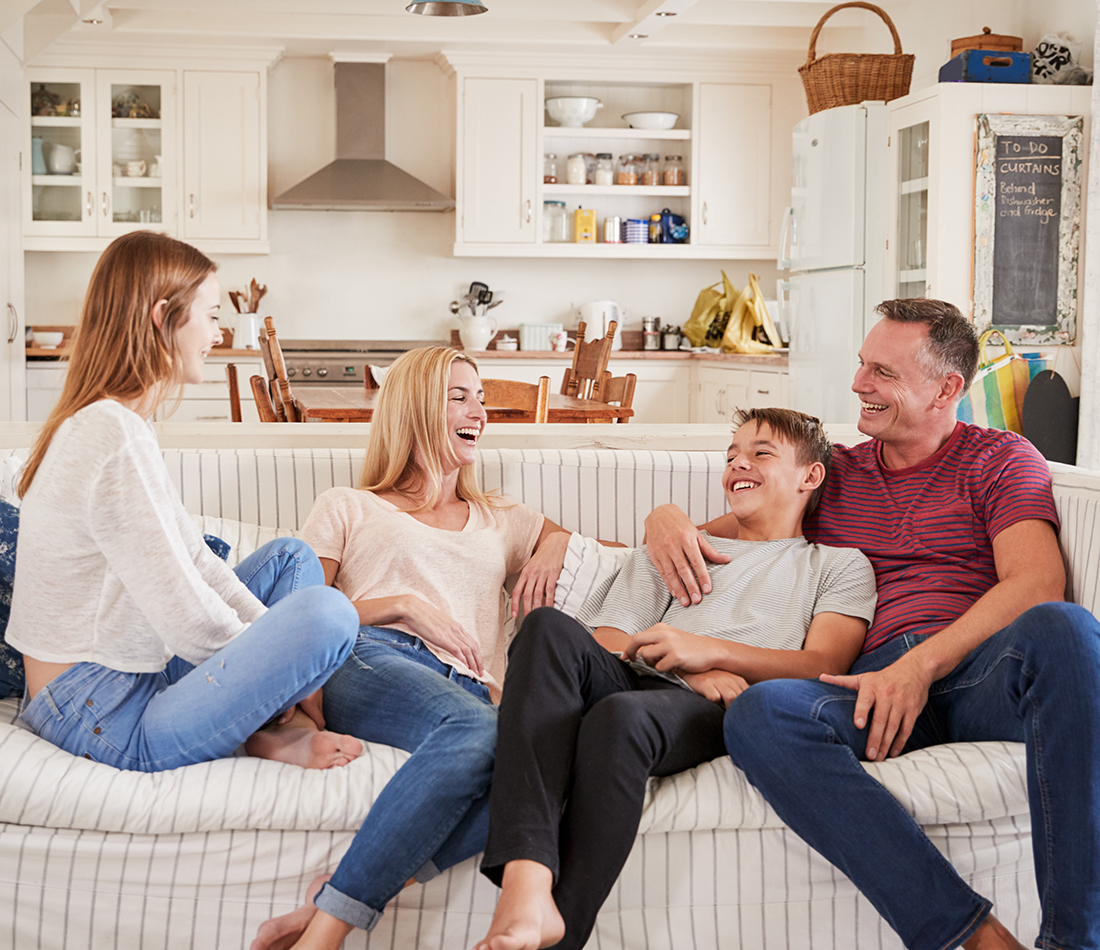 Family With Teenage Children Relaxing On Sofa Together