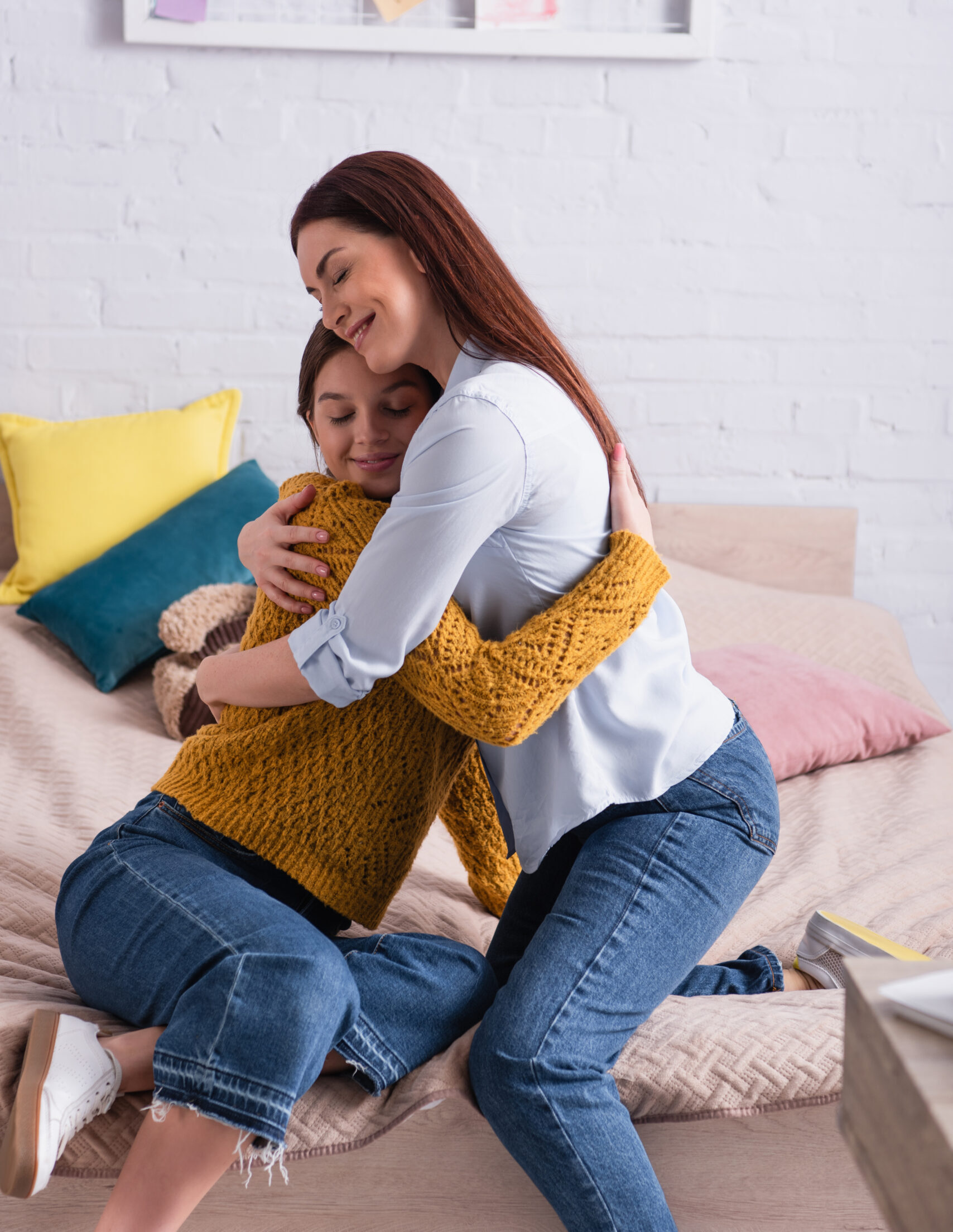 Pleased Mother And Teenage Daughter Hugging In Bedroom